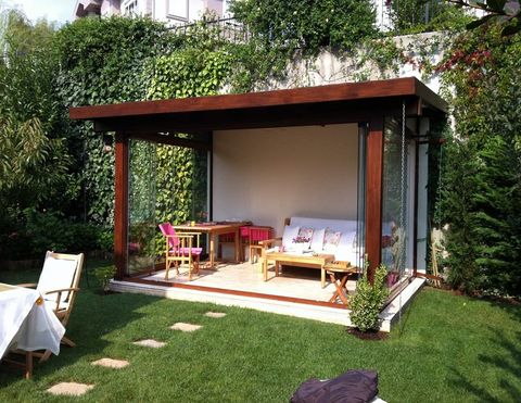 Bahcede ahsap gorunumlu pergola altinda oturma alani